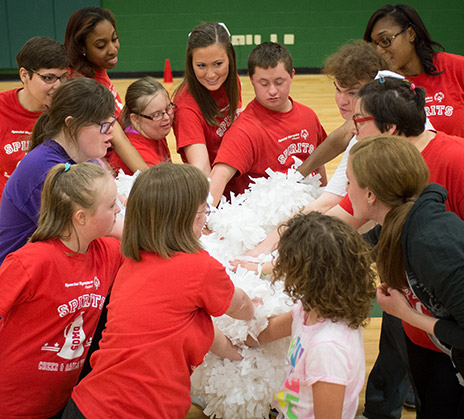 Cheer squad huddled up with hands over hands.