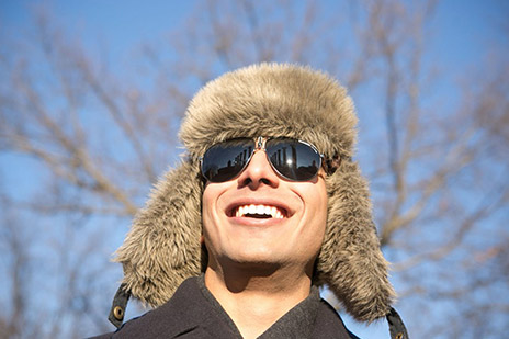 Azeem Khan smiling with Mizzou columns reflected in his sunglasses.